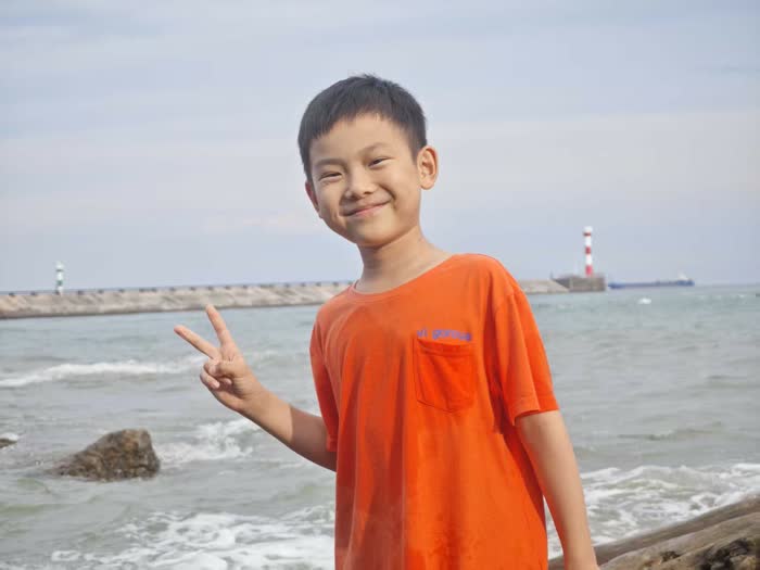 海边橙色上衣的照片
