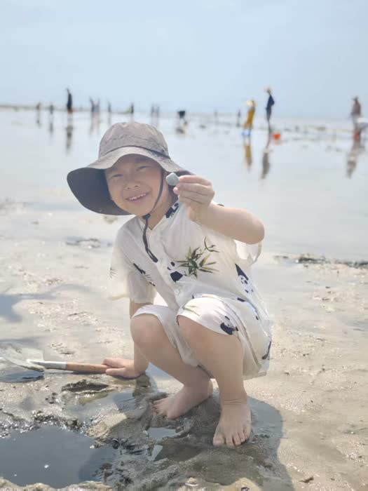 海滩上蹲下微笑的照片